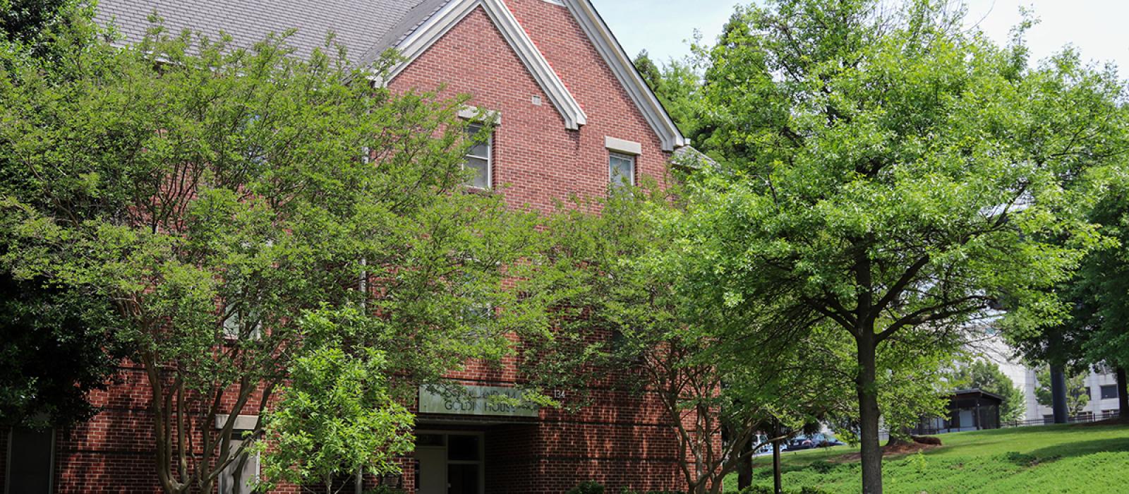 A view of Goldin entrance covered by tree canopy.