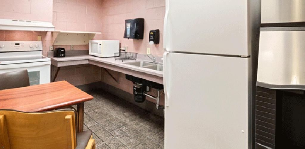 Kitchen with appliances. A table with chairs in the corner.